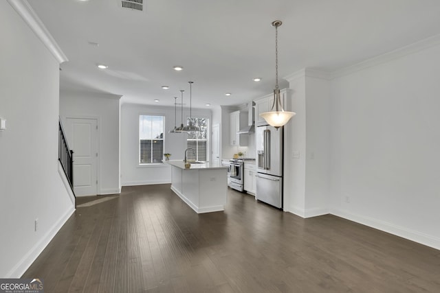 kitchen featuring pendant lighting, wall chimney range hood, appliances with stainless steel finishes, white cabinets, and a kitchen island