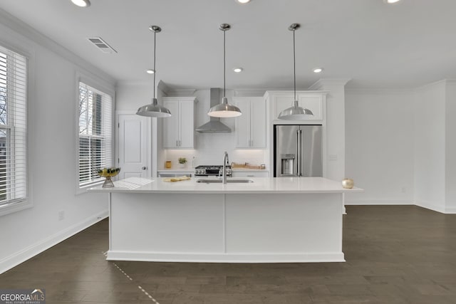 kitchen with a kitchen island with sink, wall chimney exhaust hood, high end fridge, and sink