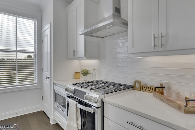 kitchen featuring stainless steel appliances, plenty of natural light, exhaust hood, and white cabinets