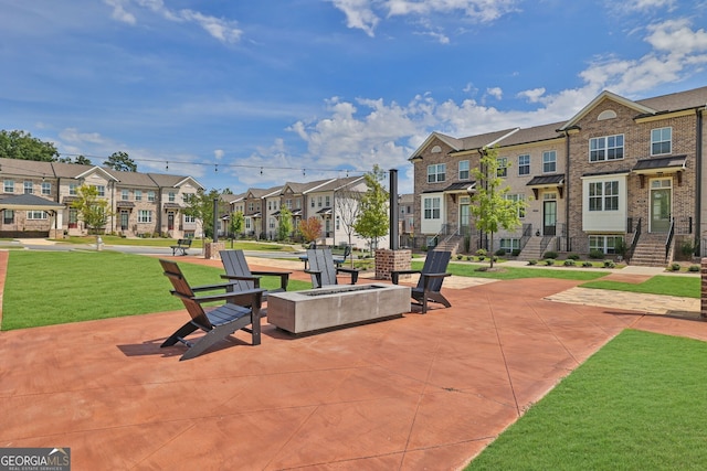 view of home's community with a lawn, a patio area, and an outdoor fire pit