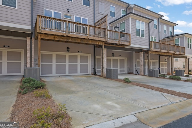 view of front of home with a garage and central air condition unit