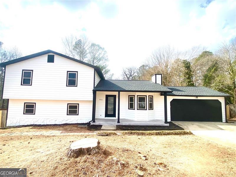 split level home featuring a garage and covered porch