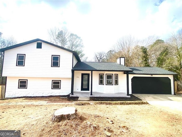 split level home featuring a garage and covered porch