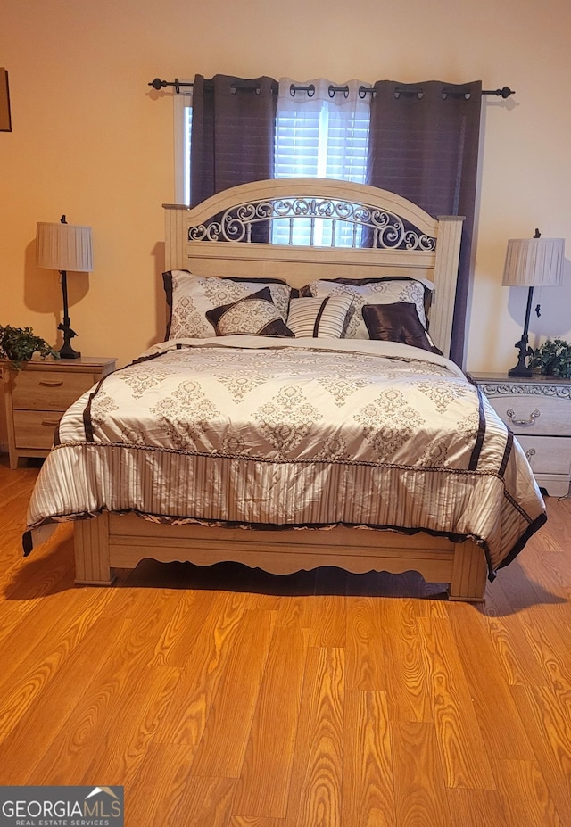 bedroom with multiple windows and light hardwood / wood-style floors