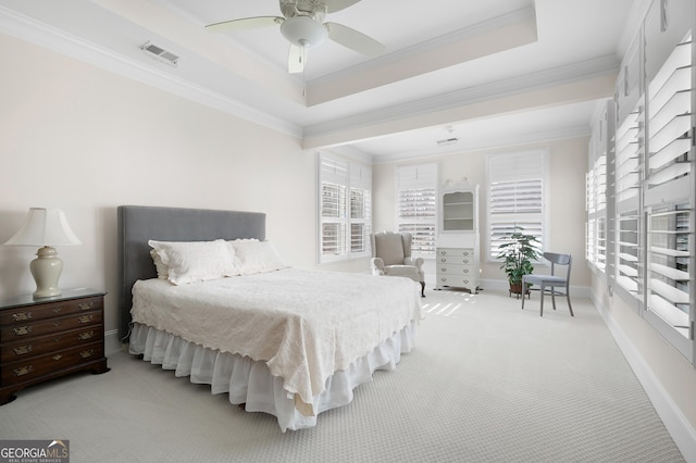 bedroom with a tray ceiling, ornamental molding, and light colored carpet