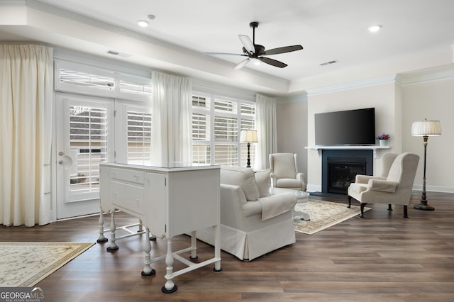 living room with ceiling fan, crown molding, dark hardwood / wood-style floors, and a raised ceiling