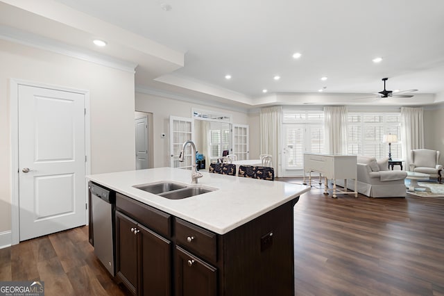 kitchen with dark hardwood / wood-style floors, sink, stainless steel dishwasher, a raised ceiling, and a center island with sink