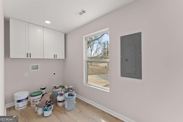 laundry area with cabinets, electric panel, electric dryer hookup, washer hookup, and light hardwood / wood-style floors