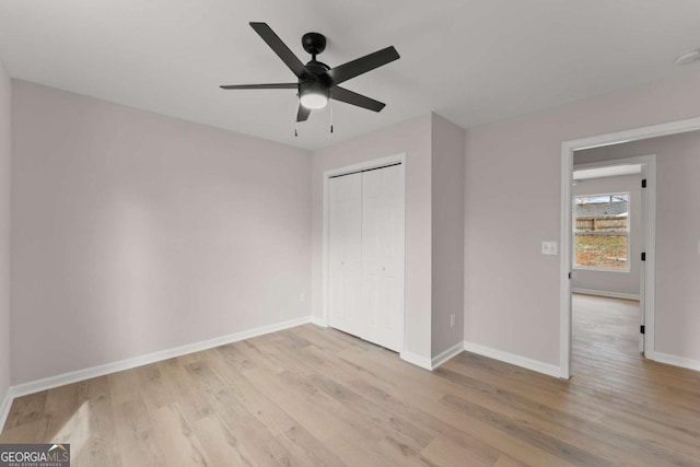 unfurnished bedroom featuring ceiling fan, light hardwood / wood-style floors, and a closet