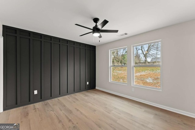 unfurnished room with ceiling fan and light wood-type flooring