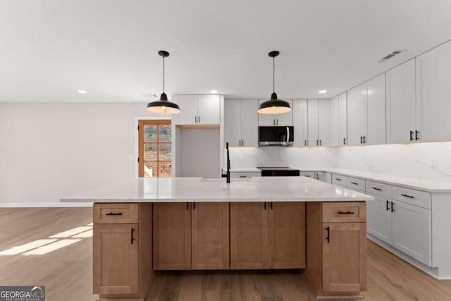 kitchen with white cabinetry, a spacious island, and decorative light fixtures