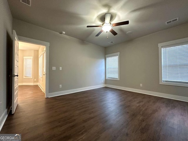 spare room with ceiling fan and dark hardwood / wood-style flooring