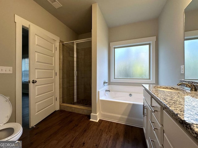 full bathroom with hardwood / wood-style flooring, vanity, shower with separate bathtub, and toilet