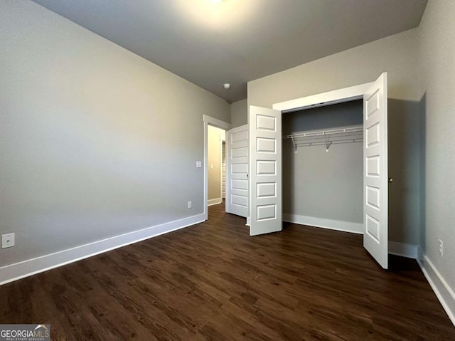 unfurnished bedroom featuring dark wood-type flooring and a closet