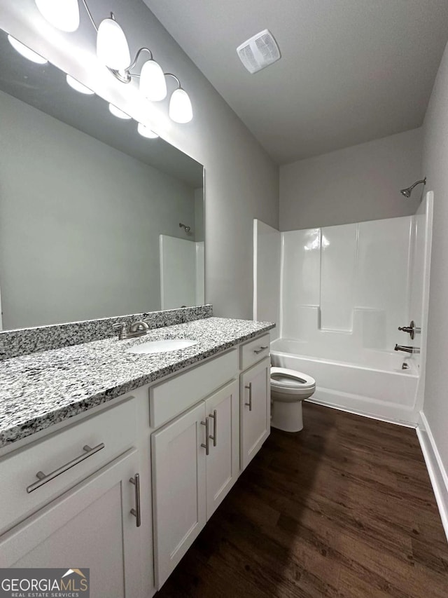 full bathroom featuring wood-type flooring, bathtub / shower combination, vanity, and toilet