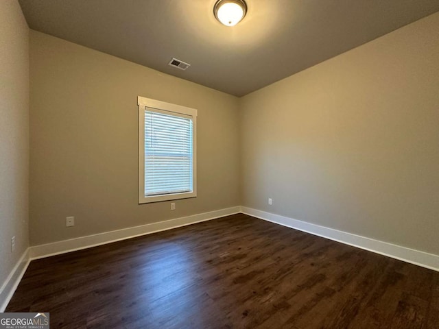 empty room with dark hardwood / wood-style flooring