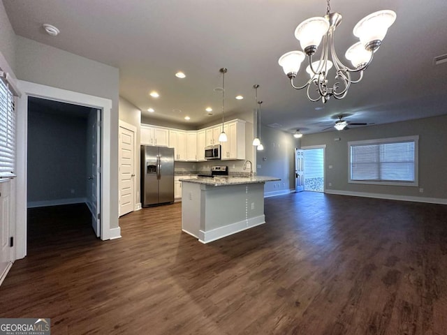 kitchen with white cabinetry, stainless steel appliances, light stone countertops, and hanging light fixtures