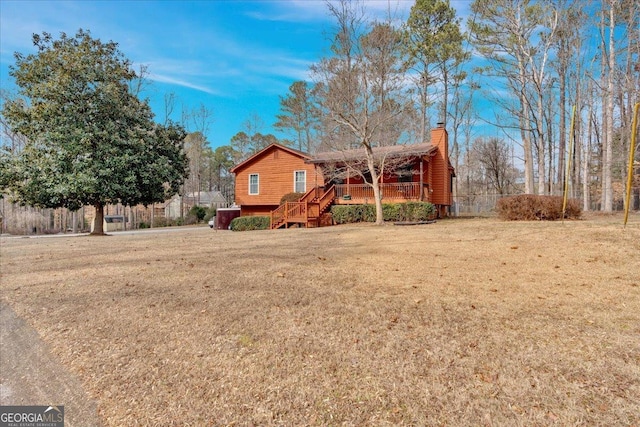 view of front of home with a wooden deck and a front lawn