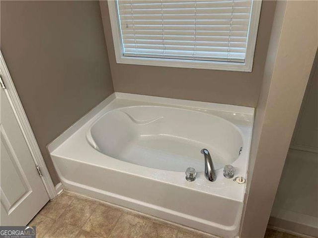 bathroom featuring a bathing tub and a wealth of natural light