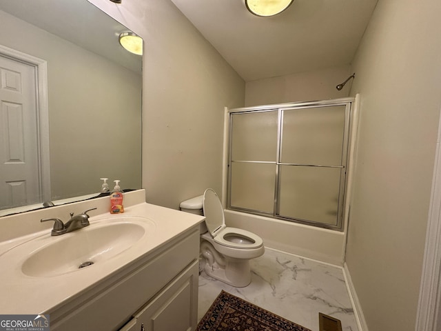 full bathroom featuring vanity, shower / bath combination with glass door, and toilet