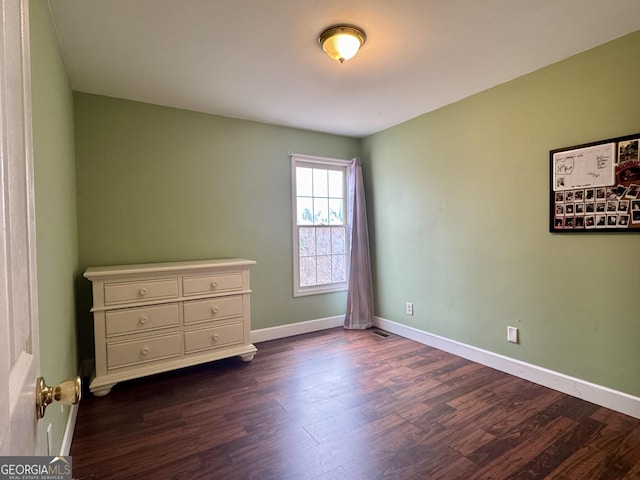 unfurnished bedroom with dark wood-type flooring