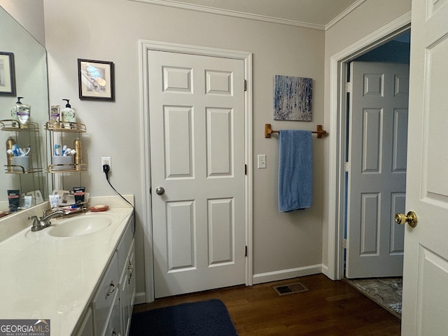 bathroom with vanity, hardwood / wood-style floors, and crown molding