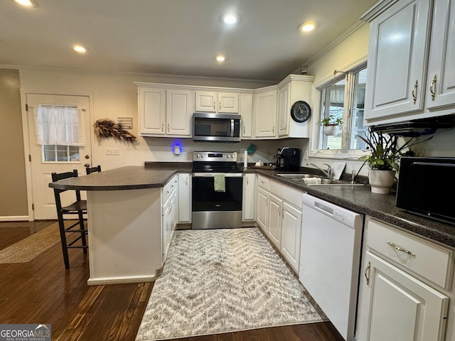 kitchen featuring dark hardwood / wood-style flooring, sink, stainless steel appliances, and white cabinets