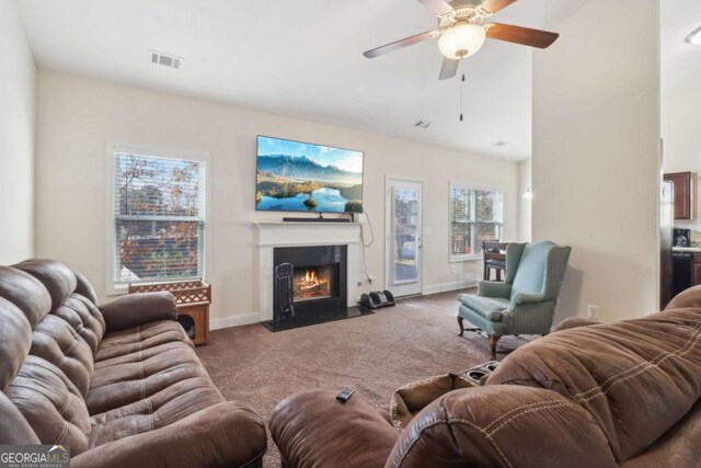 living room with vaulted ceiling, carpet floors, and ceiling fan