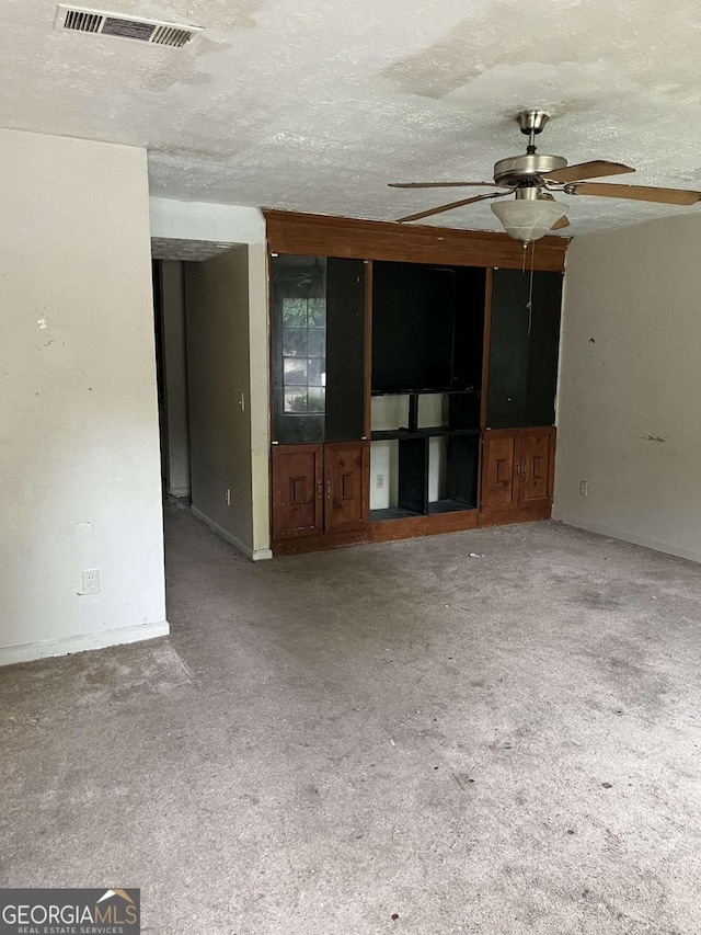 unfurnished living room with ceiling fan, carpet, and a textured ceiling