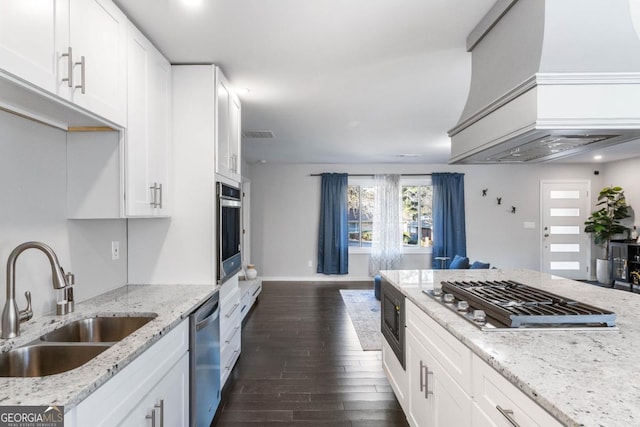 kitchen with light stone countertops, white cabinetry, appliances with stainless steel finishes, and sink