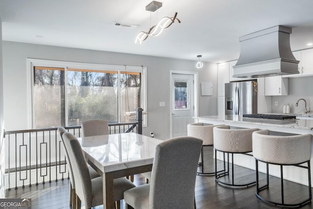 dining space with dark wood-type flooring and sink