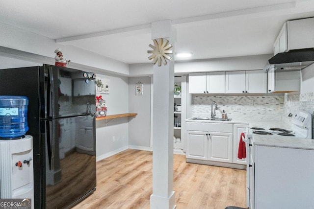 kitchen with white electric range oven, sink, black fridge, light wood-type flooring, and white cabinets