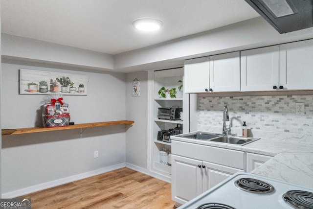 kitchen with white cabinetry, sink, tasteful backsplash, and light hardwood / wood-style floors