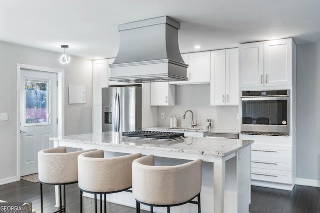 kitchen featuring stainless steel appliances, a center island, custom exhaust hood, and white cabinets