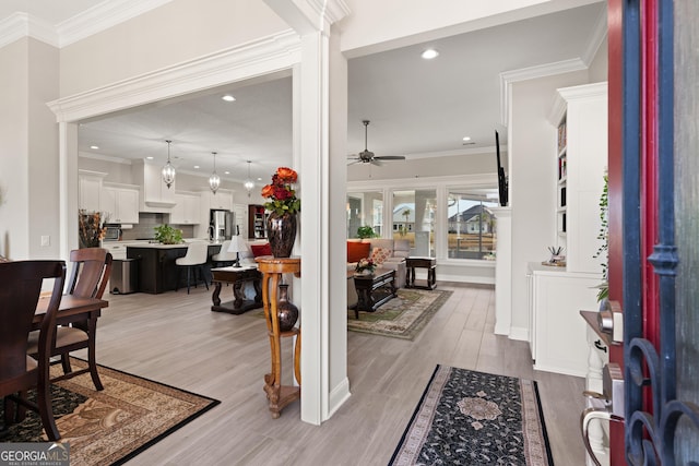 foyer featuring crown molding, ceiling fan, and light hardwood / wood-style floors