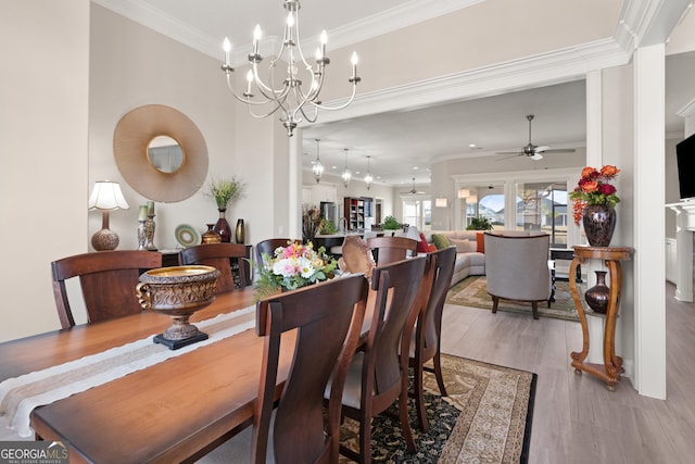 dining room featuring ornamental molding, ceiling fan with notable chandelier, and light wood-type flooring