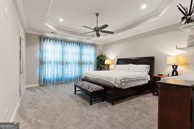 carpeted bedroom featuring crown molding, ceiling fan, and a tray ceiling