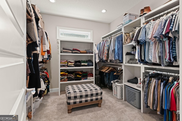 walk in closet with light carpet