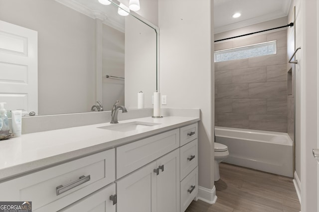 full bathroom with hardwood / wood-style floors, tiled shower / bath combo, vanity, toilet, and crown molding