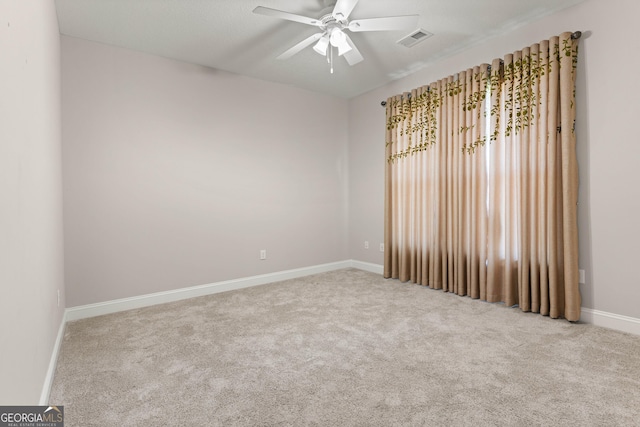 carpeted spare room featuring ceiling fan