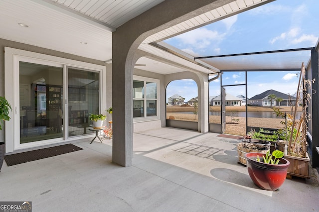 sunroom featuring a water view