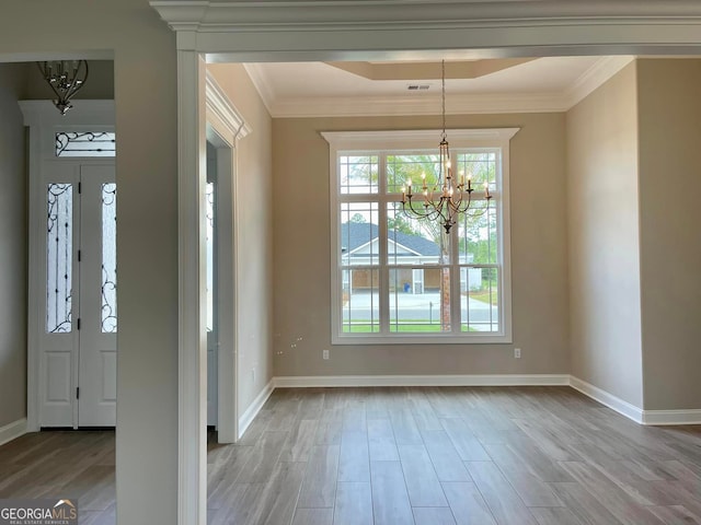 foyer entrance featuring crown molding, a notable chandelier, and light hardwood / wood-style flooring