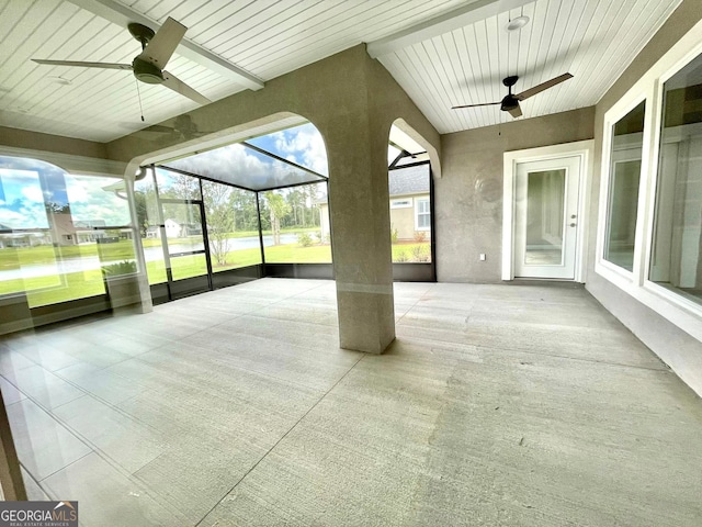 unfurnished sunroom with ceiling fan