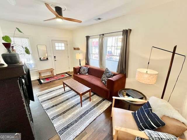 living room with dark hardwood / wood-style floors and ceiling fan