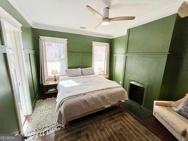 bedroom featuring crown molding, dark parquet flooring, and ceiling fan