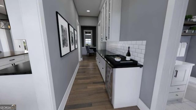 kitchen with white cabinetry, dark hardwood / wood-style floors, and backsplash