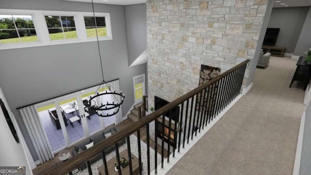 stairs featuring carpet flooring, a fireplace, and a chandelier