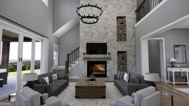 living room with hardwood / wood-style flooring, a towering ceiling, a fireplace, and an inviting chandelier