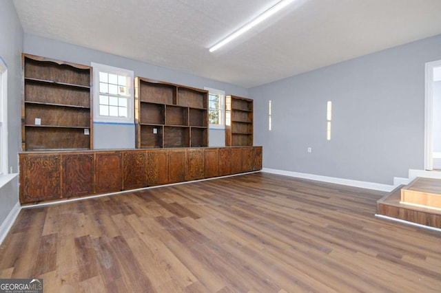 unfurnished living room featuring wood-type flooring and a textured ceiling