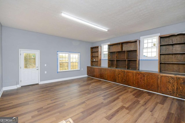 empty room featuring wood-type flooring and a textured ceiling